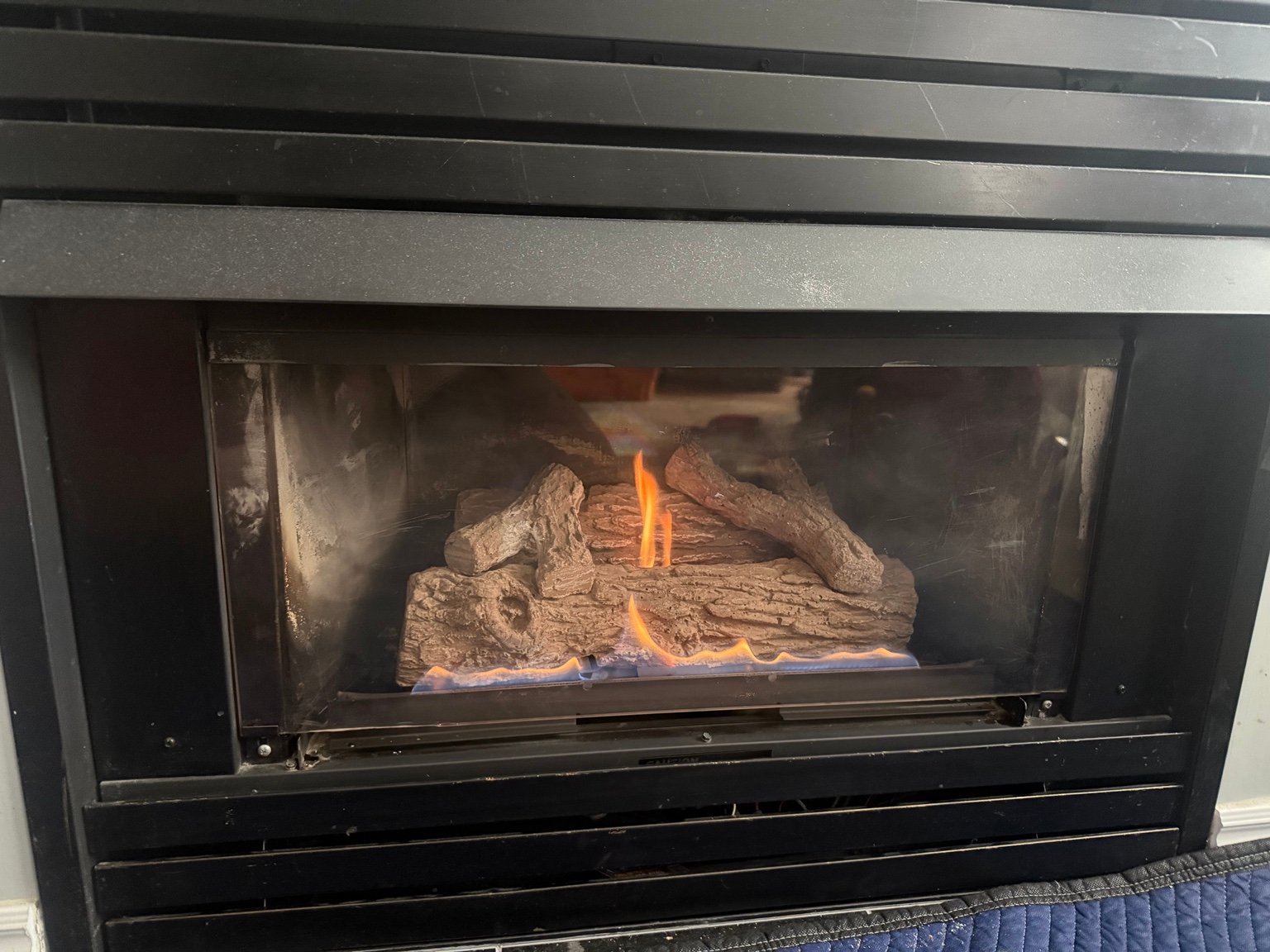 Gas fireplace with visible flames and a dark metal surround